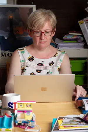 Una looking serious at her laptop